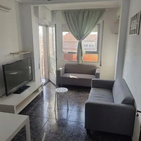 Salón luminoso con dos sofás y salida a balcón